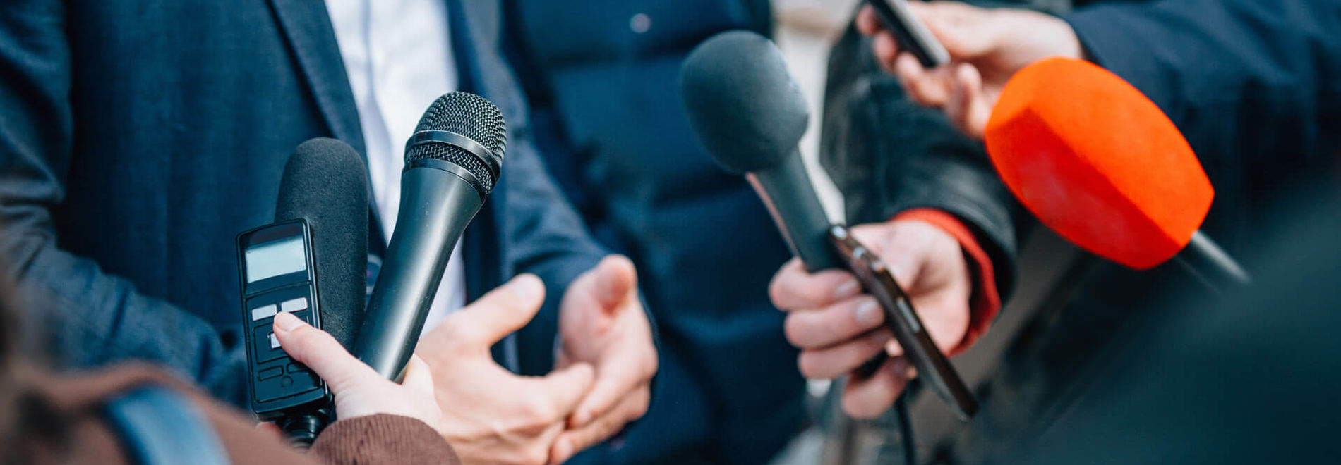 Pressemikrofone, die für ein Interview gehalten werden